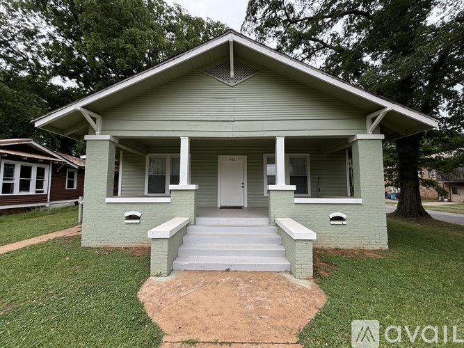 A small house with a front porch is for sale.