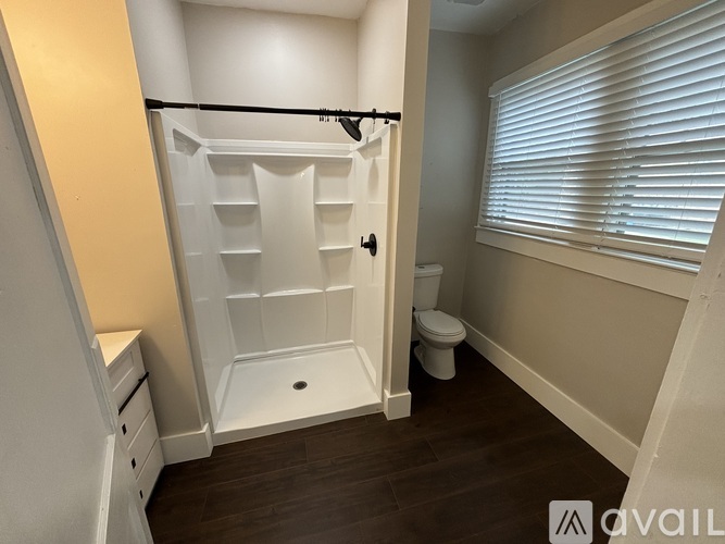 A small bathroom with a walk-in shower and toilet.