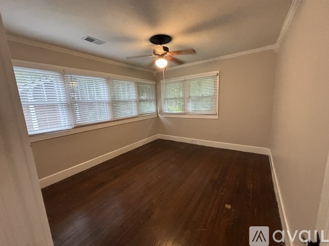 A room with a ceiling fan and wooden flooring.
