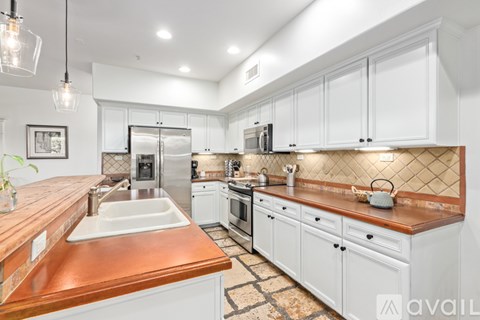 A kitchen with white cabinets and a copper countertop.