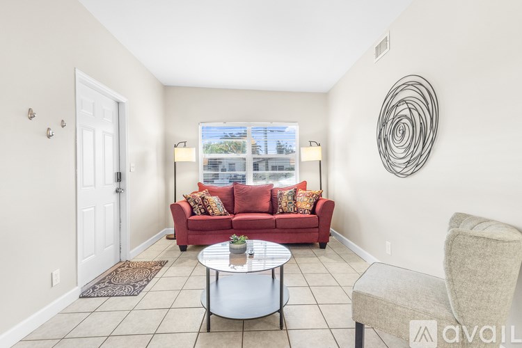 A living room with a red couch and a white door.