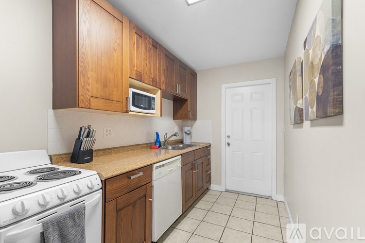 A kitchen with white appliances and wooden cabinets.