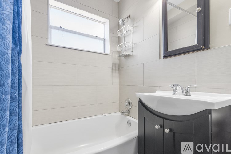 A bathroom with a white sink and a bathtub with a blue shower curtain.