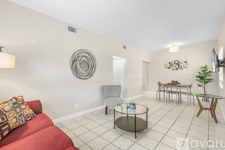 A living room with a red couch and a glass coffee table.