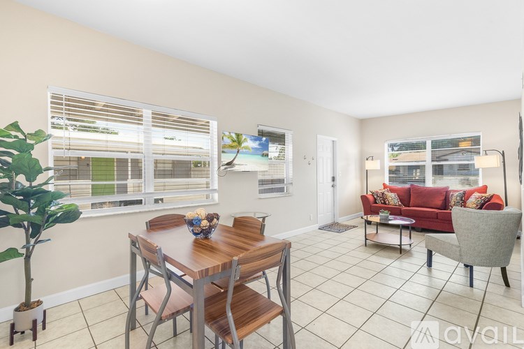 A living room with a couch, chair, and dining table.