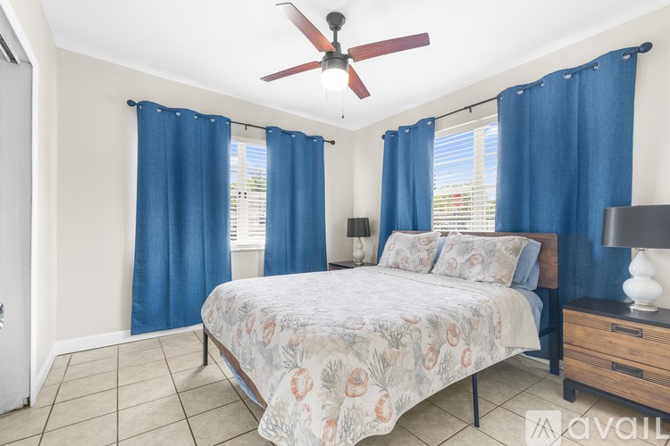 A bedroom with a bed, nightstand, and ceiling fan.