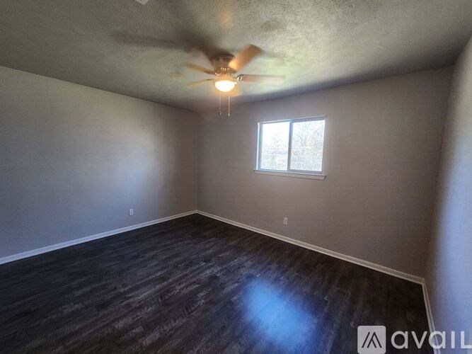 A room with a ceiling fan and a window.