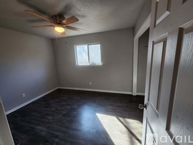 A room with a ceiling fan and a window.