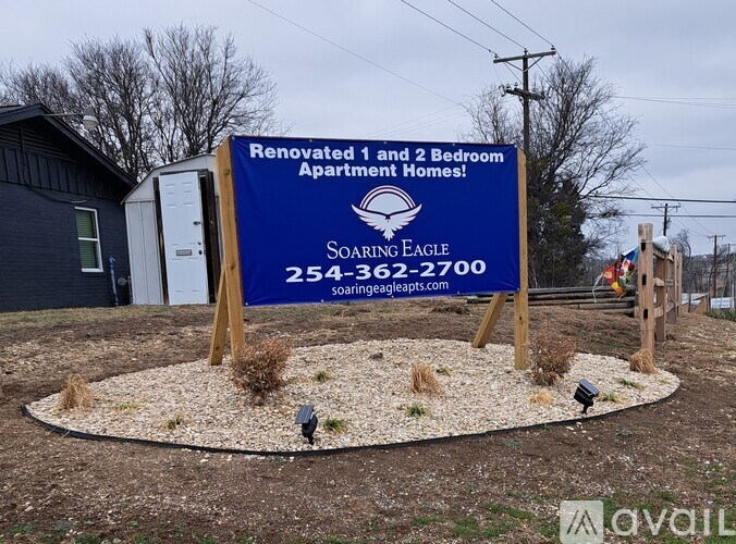 A sign for Soaring Eagle Apartments is displayed in front of a building.