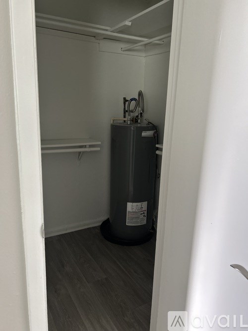 A small room with a water heater and a pipe.