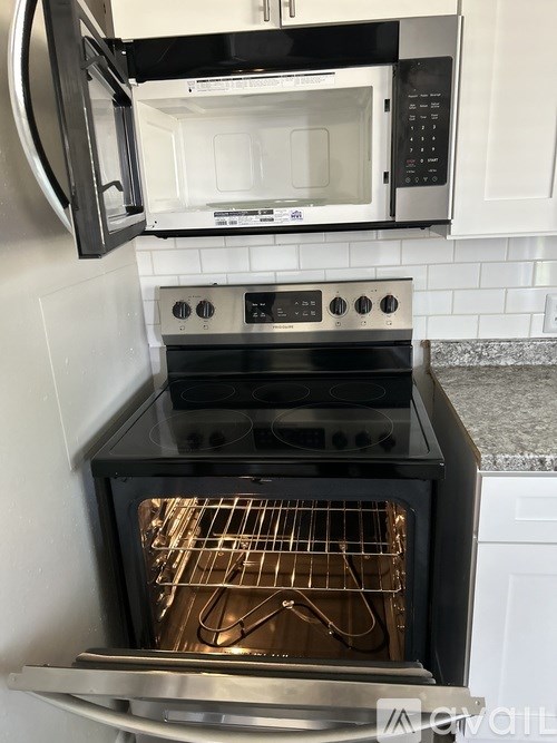A black oven with the door open is in a kitchen.