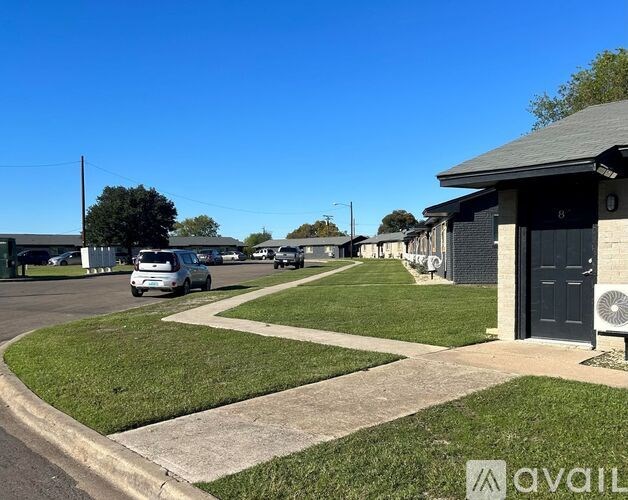 A sunny day at a residential area with houses and cars.