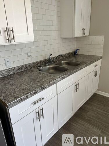 A kitchen with granite countertops and white cabinets.
