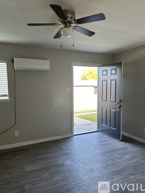 A room with a ceiling fan and a door leading outside.