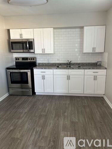 A kitchen with white cabinets and a black stove top oven.