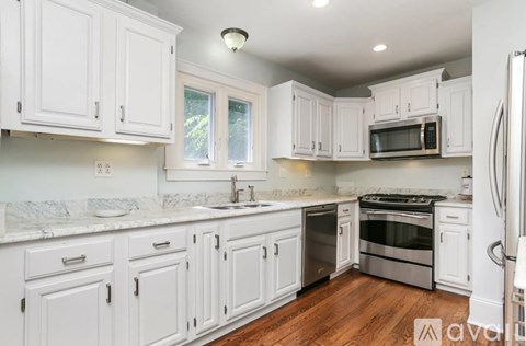 A kitchen with white cabinets and appliances.
