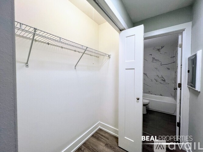 A spacious room with a wood floor and a wall-mounted refrigerator.