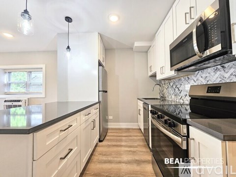 A spacious room with a window, a mirror, and a wall-mounted air conditioner unit.