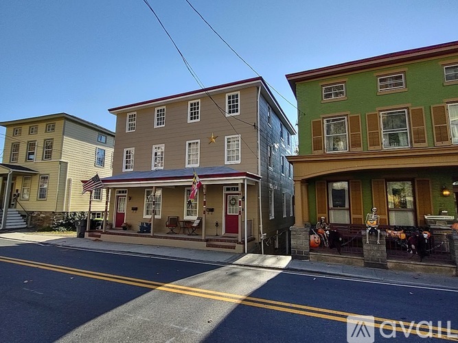 A row of three colorful buildings with a clear blue sky above them.