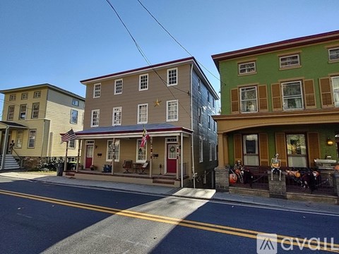 A row of three colorful buildings with a clear blue sky above them.