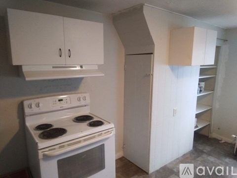 A white stove and cabinet in a kitchen.