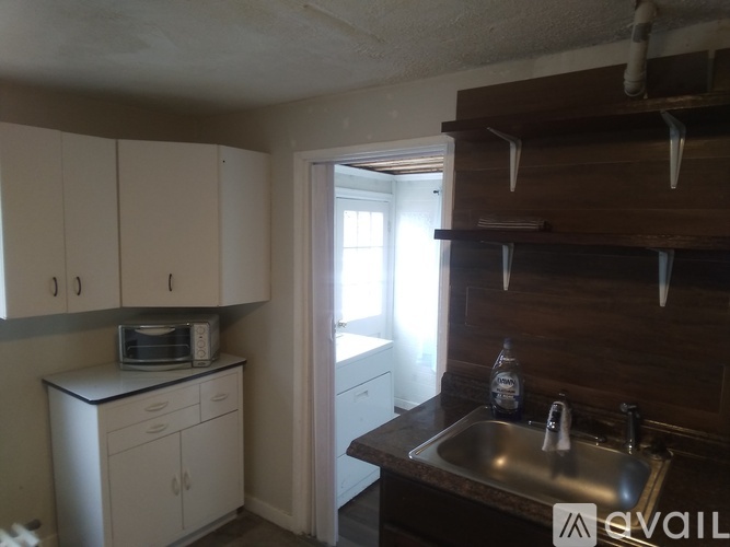 A kitchen with white cabinets and a brown counter.