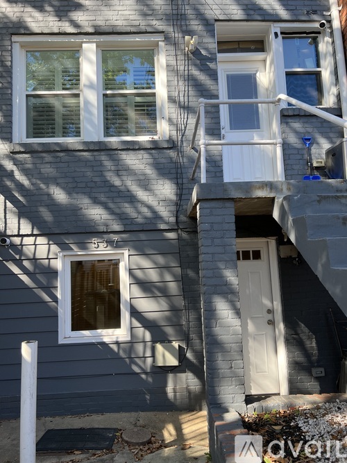 A grey house with a white door and windows.