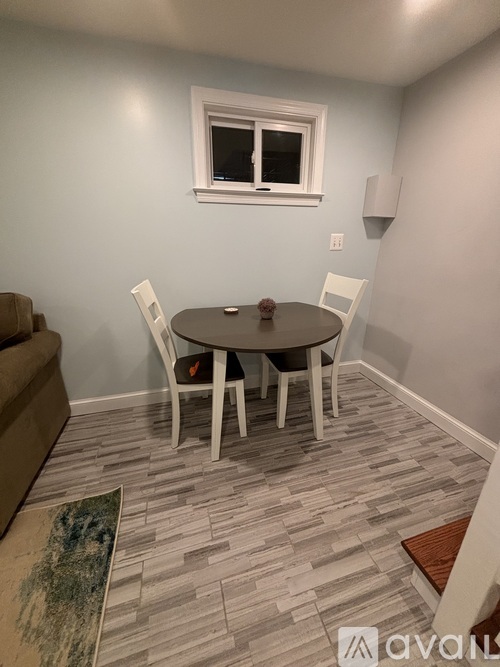 A dining room with a round table and chairs.