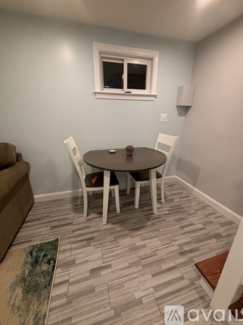 A dining room with a round table and chairs.