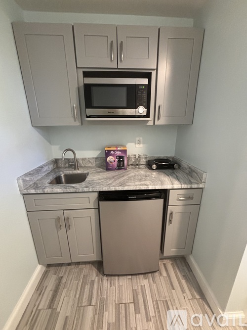 A kitchen with a dishwasher, microwave, and sink.