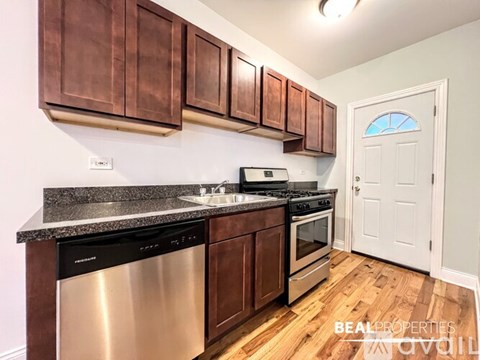 A kitchen with brown cabinets and a white door.