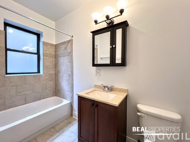 A bathroom with a white tub, sink, and toilet.