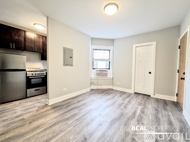 A room with a window and wooden flooring.