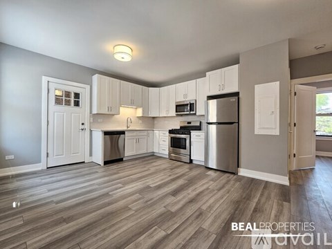 A kitchen with white cabinets and a wooden floor.