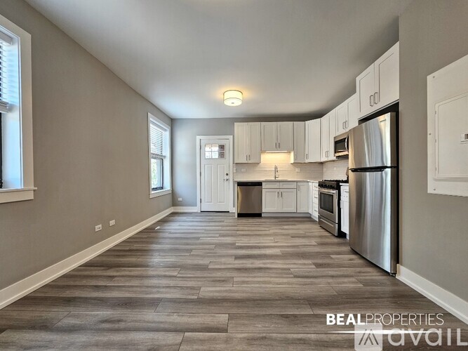 A spacious kitchen with white cabinets and stainless steel appliances.