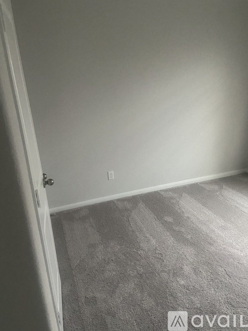 A room with a carpeted floor and a door.