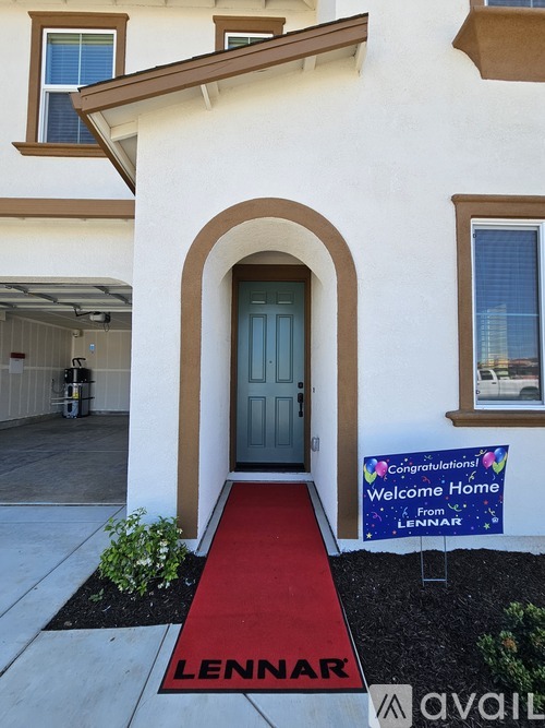 A house with a red carpet leading to a blue door and a congratulations sign from Lennar.