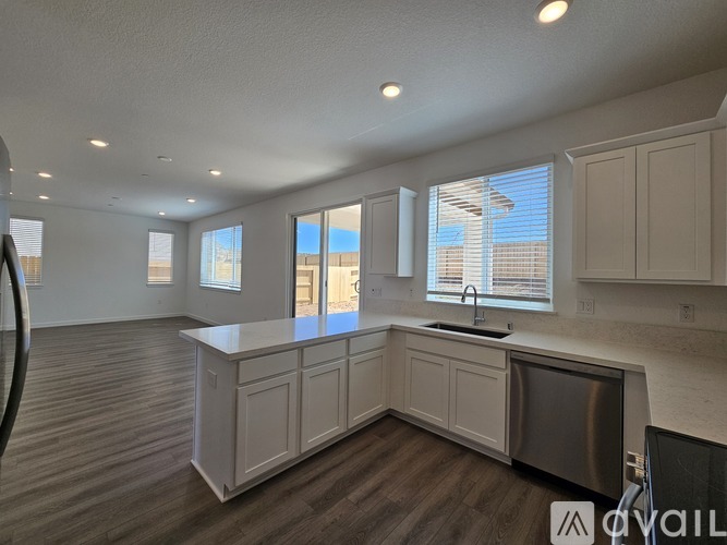 A kitchen with a sink, cabinets, and a window.
