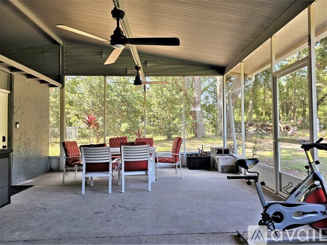 A patio with a ceiling fan, chairs, and a bicycle.