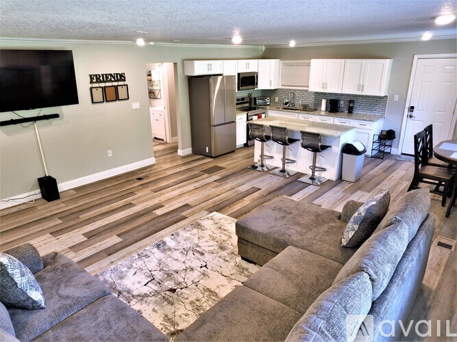 A living room with a grey couch and a wooden floor.