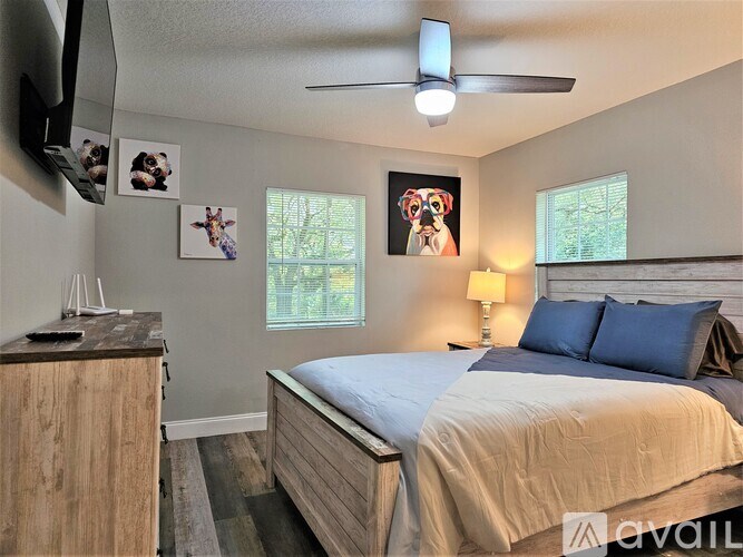 A bedroom with a bed, nightstand, and pictures on the wall.