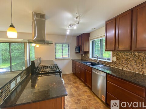 A kitchen with wooden cabinets and a black countertop.