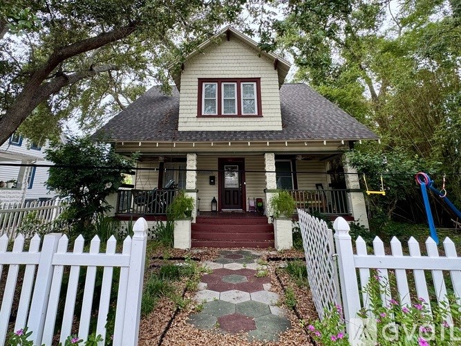 A small house with a white picket fence in front.