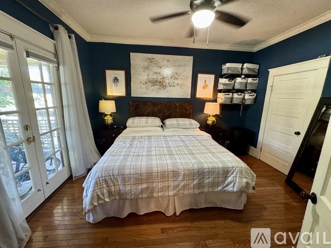 A bedroom with a bed, two lamps, and a ceiling fan.