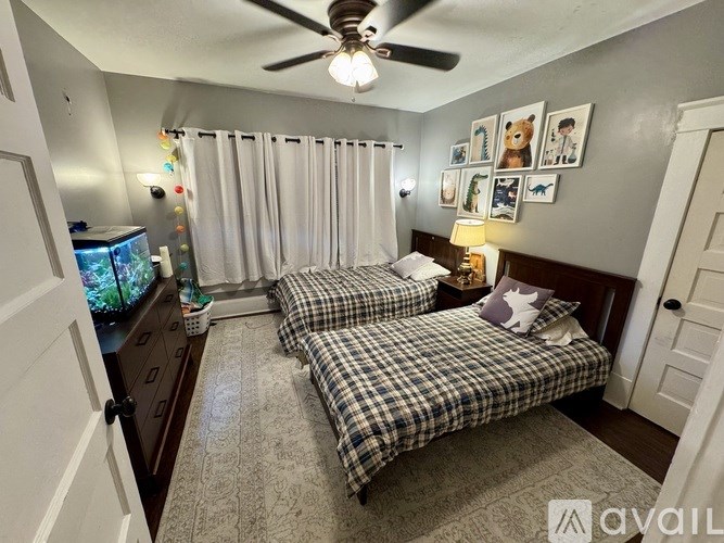 A bedroom with two beds and a ceiling fan.
