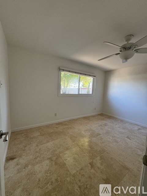 A room with a ceiling fan and a window.
