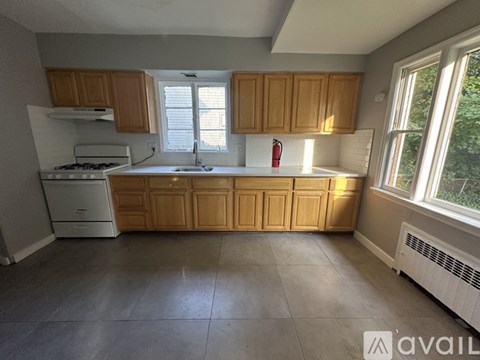 A kitchen with wooden cabinets and a white stove.