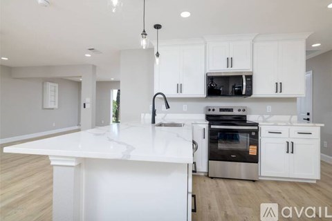 A modern kitchen with white cabinets and a large island.