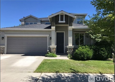 A two-story house with a garage door and a front door.