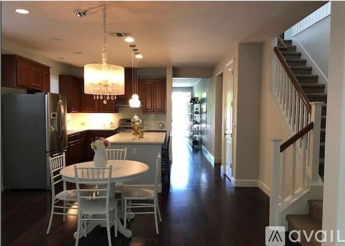 A kitchen with a table and chairs and a staircase.